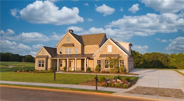 craftsman house featuring a garage and a front lawn