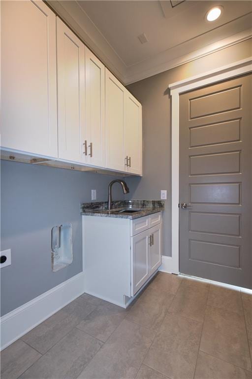 clothes washing area with sink, electric dryer hookup, light tile patterned floors, and cabinets