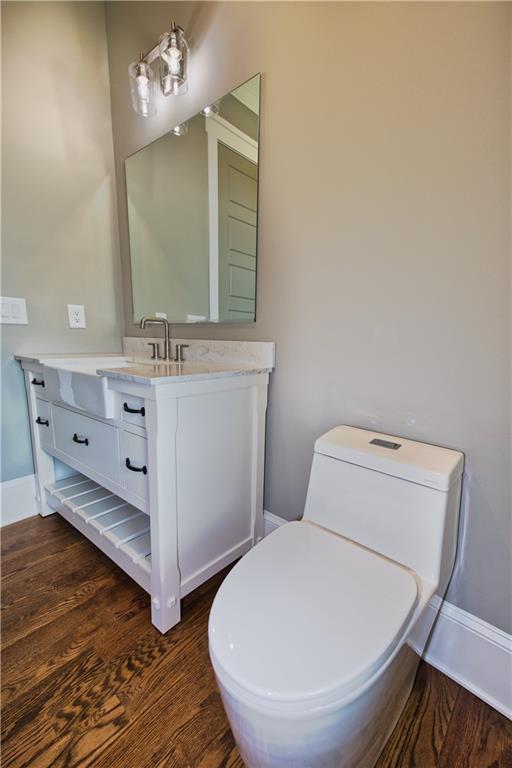 bathroom featuring toilet, vanity, and wood-type flooring