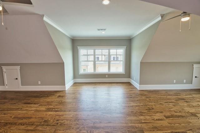 additional living space with ceiling fan, vaulted ceiling, and wood-type flooring