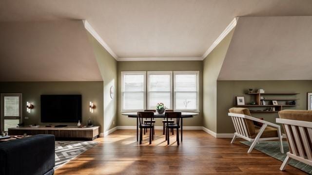 living room featuring hardwood / wood-style flooring, crown molding, and lofted ceiling