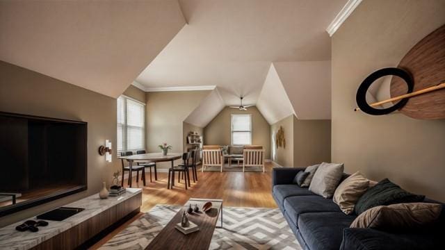 living room with vaulted ceiling, light wood-type flooring, plenty of natural light, and ornamental molding