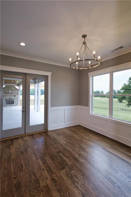 interior space with dark wood-type flooring, a chandelier, ornamental molding, and french doors