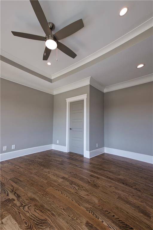 empty room featuring hardwood / wood-style flooring, ornamental molding, and ceiling fan