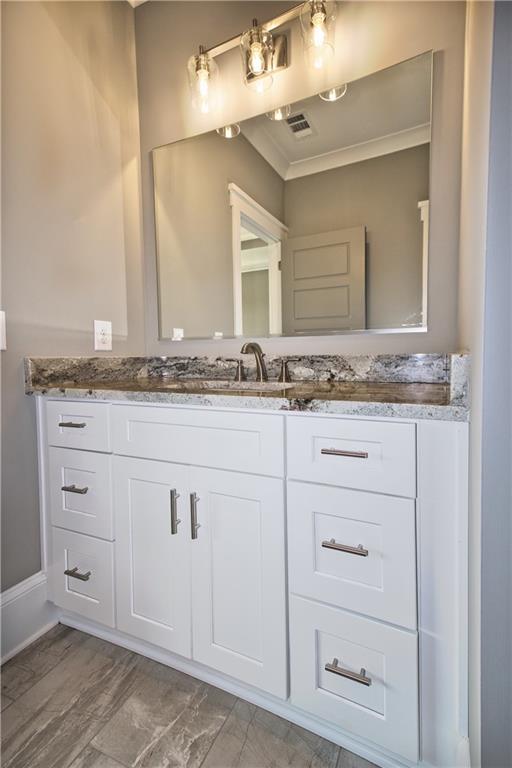 bathroom with crown molding and vanity