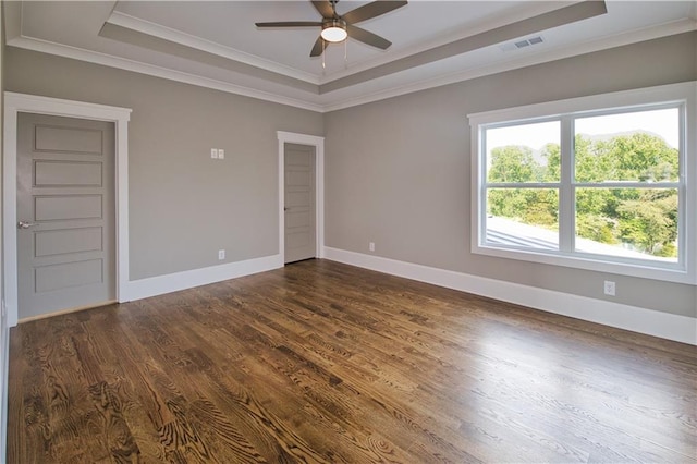 unfurnished room featuring hardwood / wood-style flooring, a tray ceiling, and ceiling fan