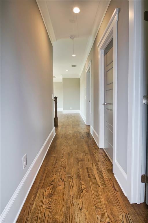 corridor with hardwood / wood-style flooring and ornamental molding