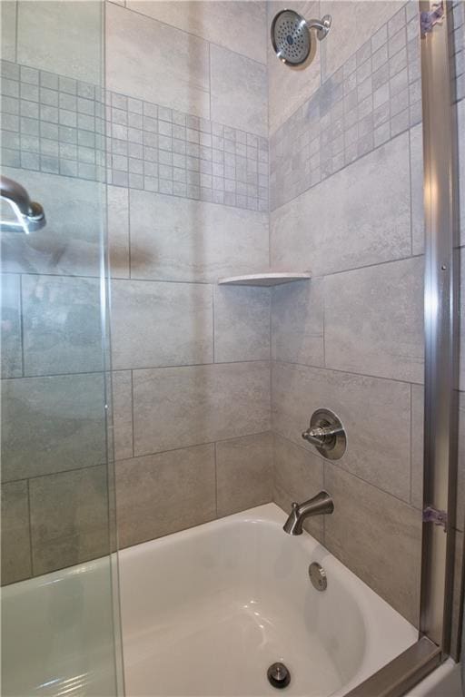 bathroom featuring combined bath / shower with glass door