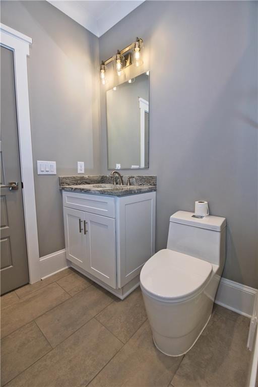 bathroom with toilet, vanity, and tile patterned floors