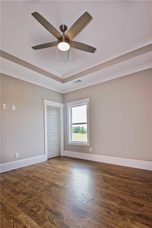 unfurnished room with ceiling fan, a tray ceiling, and hardwood / wood-style floors