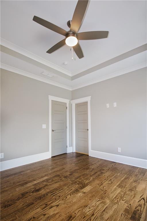 unfurnished room featuring a tray ceiling, ceiling fan, crown molding, and wood-type flooring