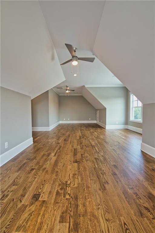 additional living space featuring ceiling fan, vaulted ceiling, and hardwood / wood-style flooring