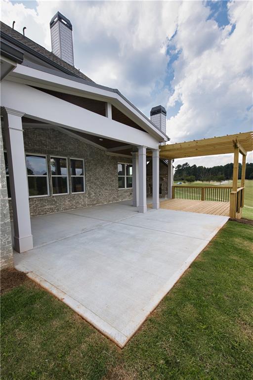 rear view of house featuring a yard and a patio