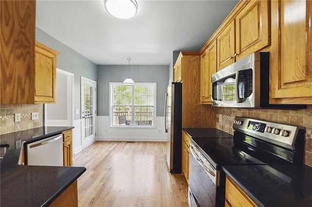 336 Toto Dr, Dawsonville, GA 30534 - kitchen featuring hanging light fixtures, decorative backsplash, appliances with stainless steel finishes, a wainscoted wall, and light wood finished floors