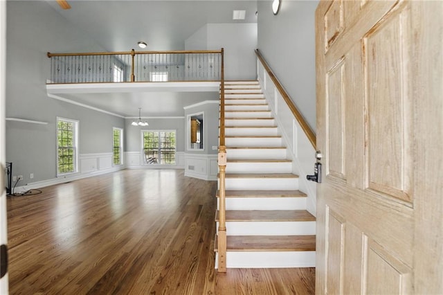 336 Toto Dr, Dawsonville, GA 30534 - staircase with wainscoting, wood finished floors, an inviting chandelier, and a towering ceiling