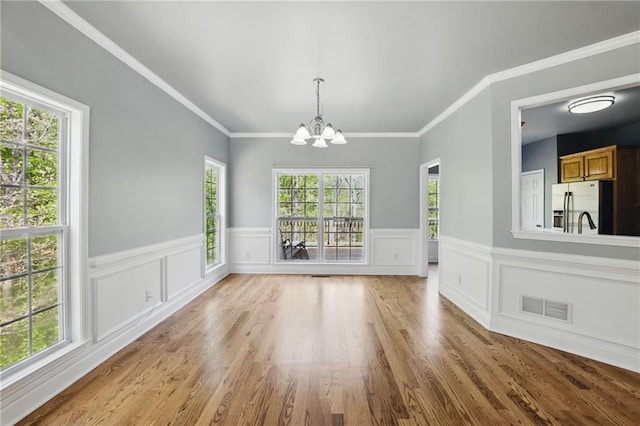 336 Toto Dr, Dawsonville, GA 30534 - unfurnished dining area with wood finished floors, visible vents, a wainscoted wall, and a notable chandelier