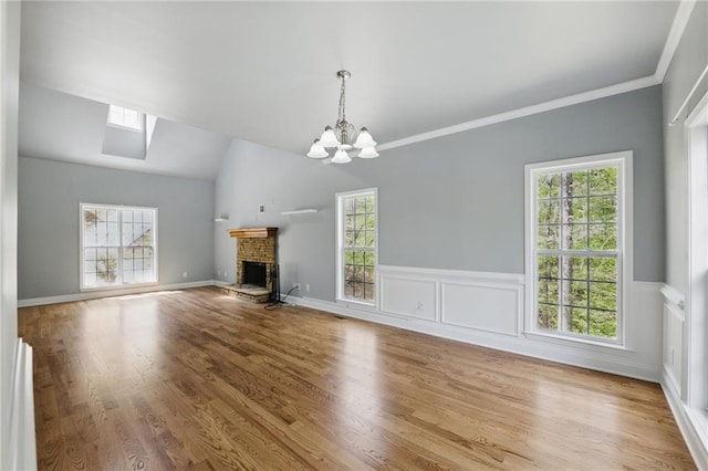 336 Toto Dr, Dawsonville, GA 30534 - unfurnished living room with wood finished floors, a chandelier, wainscoting, ornamental molding, and a fireplace
