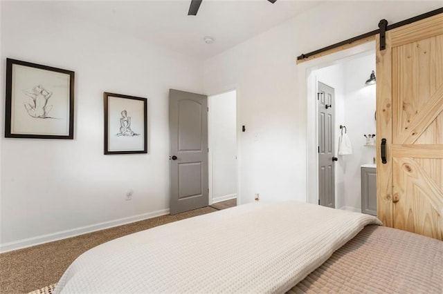 carpeted bedroom featuring a barn door, connected bathroom, and ceiling fan