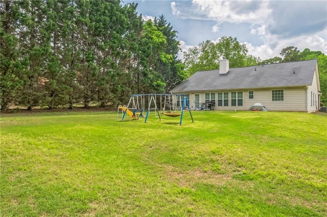 2606 Fairmont Park Ct, Dacula, GA 30019 - back of house featuring a playground, a chimney, and a lawn