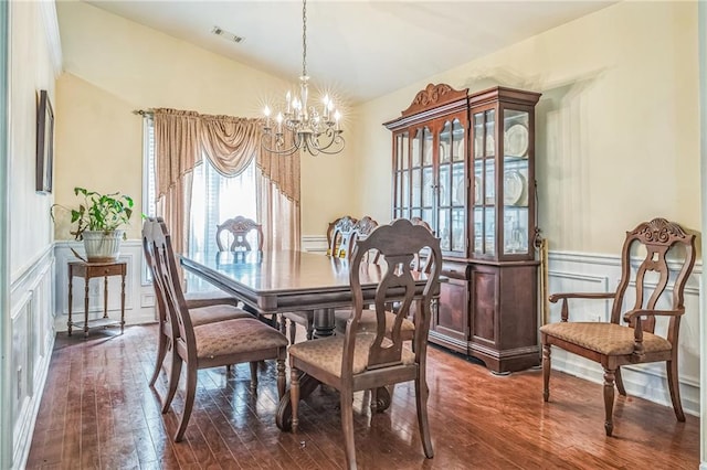 2606 Fairmont Park Ct, Dacula, GA 30019 - dining area with lofted ceiling, dark wood-type flooring, visible vents, an inviting chandelier, and wainscoting