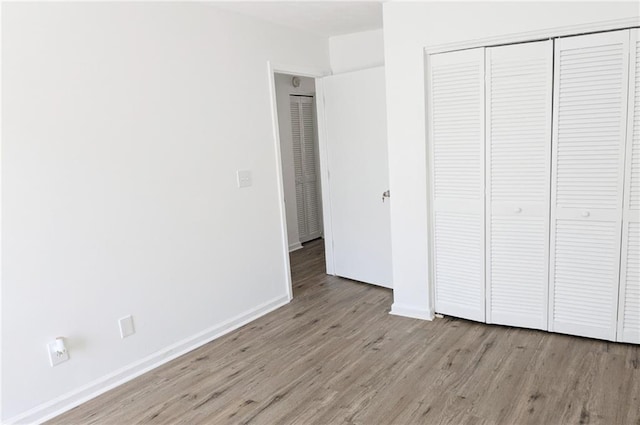 unfurnished bedroom with light hardwood / wood-style flooring and a closet