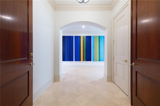 interior space featuring arched walkways, baseboards, and crown molding