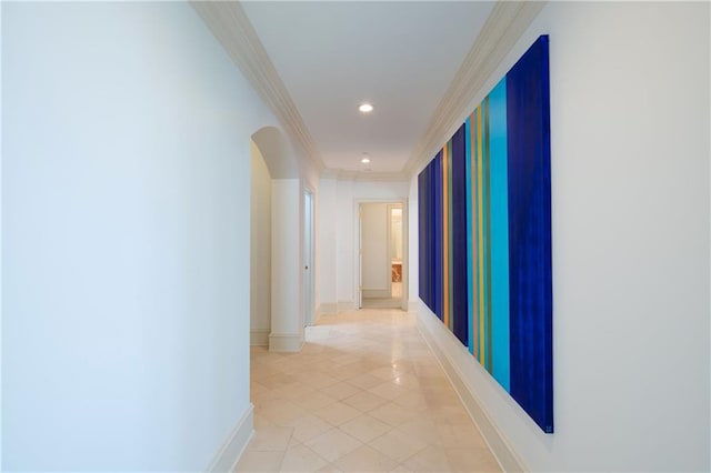 hall featuring arched walkways, light tile patterned flooring, recessed lighting, baseboards, and crown molding