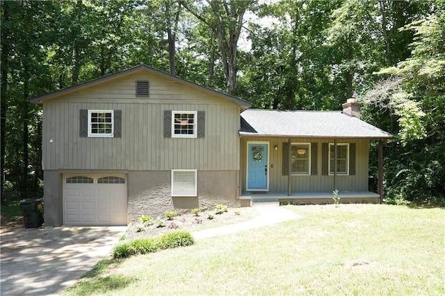 split level home featuring covered porch, a garage, and a front yard