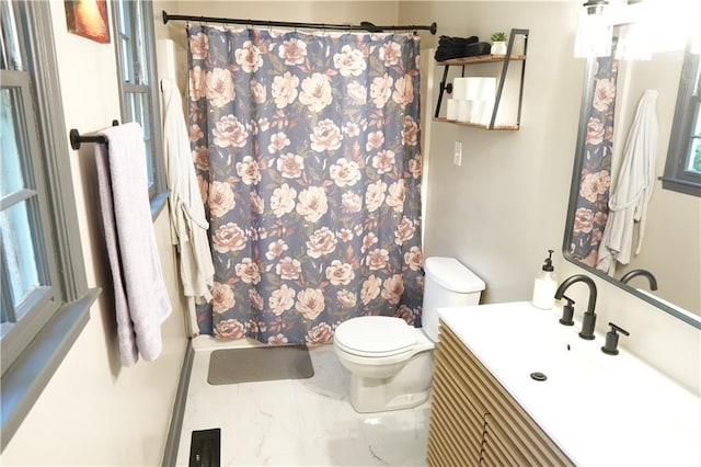 bathroom with a shower with curtain, vanity, toilet, and a healthy amount of sunlight