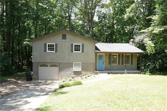 tri-level home with covered porch, a garage, and a front yard