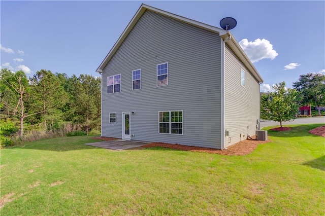 rear view of property with cooling unit, a yard, and a patio area