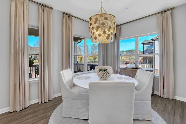 dining area featuring baseboards, an inviting chandelier, and wood finished floors