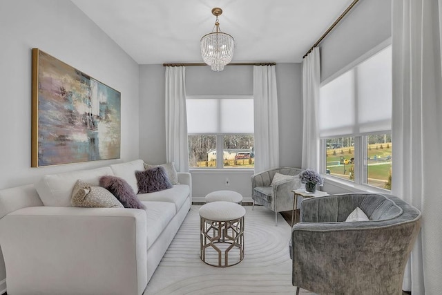 sitting room featuring an inviting chandelier and baseboards