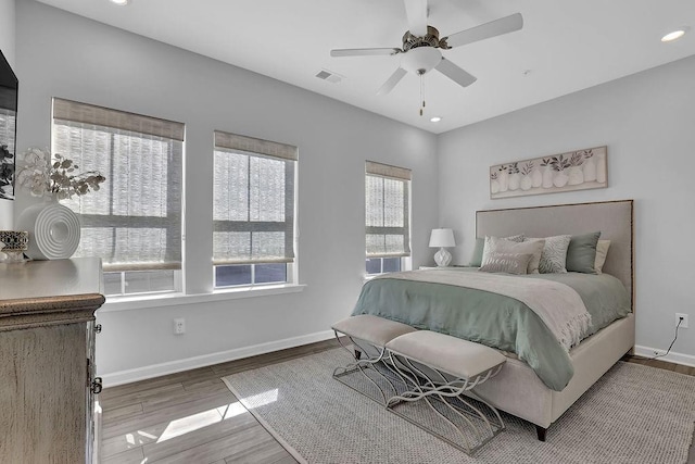 bedroom with visible vents, baseboards, wood finished floors, and recessed lighting