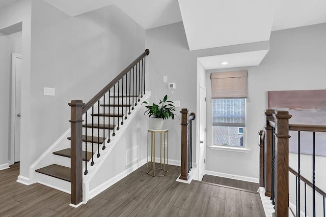 entrance foyer featuring stairway, wood finished floors, visible vents, and baseboards