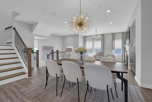 dining area featuring recessed lighting, stairway, a notable chandelier, and wood finished floors