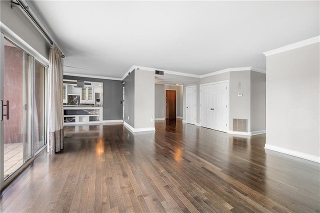 unfurnished living room with crown molding and dark wood-type flooring