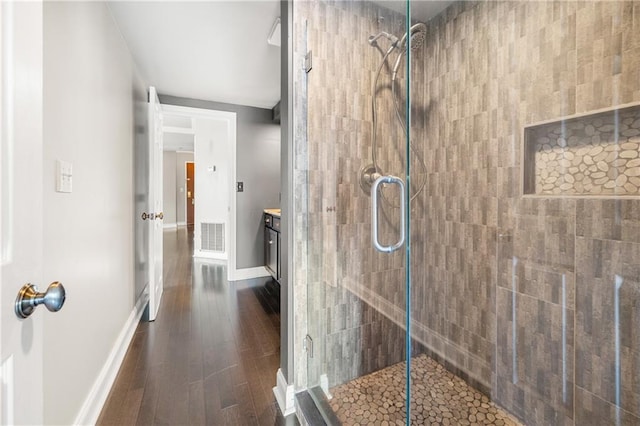 bathroom featuring hardwood / wood-style floors, vanity, and tiled shower