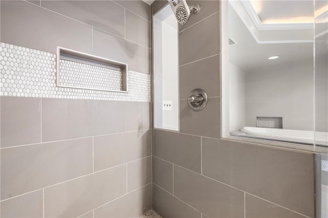 bathroom with a tile shower and crown molding