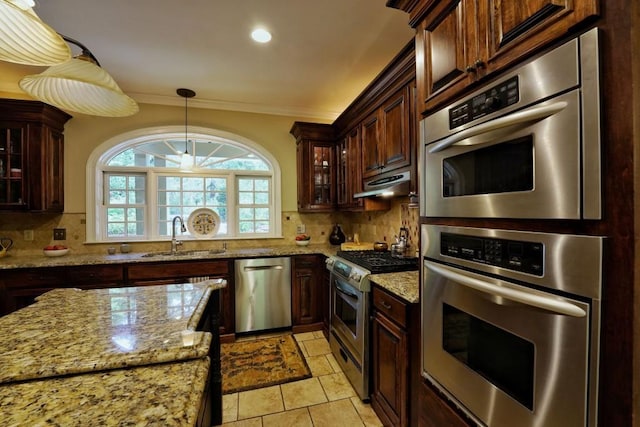 kitchen with appliances with stainless steel finishes, tasteful backsplash, light stone counters, light tile floors, and sink