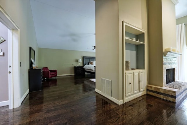 living room with ceiling fan, built in shelves, dark wood-type flooring, and high vaulted ceiling