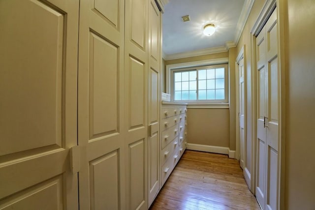 hall with ornamental molding and light wood-type flooring