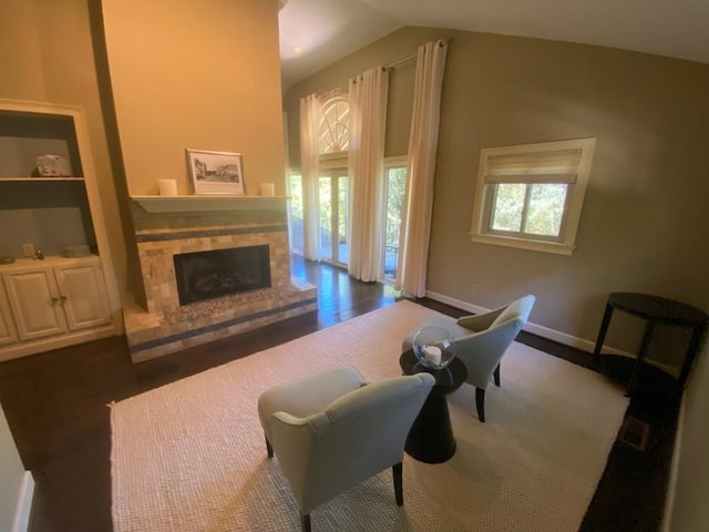 living room featuring built in features, lofted ceiling, and dark hardwood / wood-style flooring