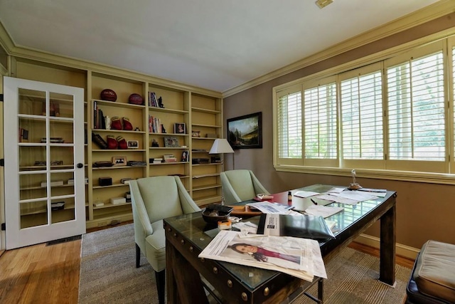 home office featuring built in features, hardwood / wood-style floors, and ornamental molding