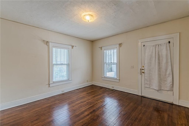 foyer entrance with dark hardwood / wood-style flooring and a textured ceiling