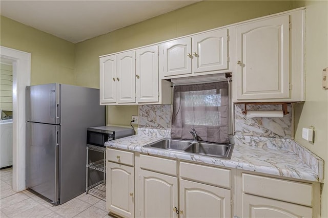 kitchen featuring tasteful backsplash, white cabinetry, appliances with stainless steel finishes, and sink