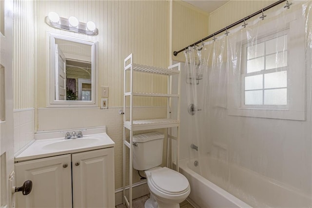 full bathroom featuring vanity, toilet, shower / bath combo with shower curtain, and tile walls