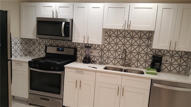 kitchen with a sink, stainless steel appliances, and light countertops