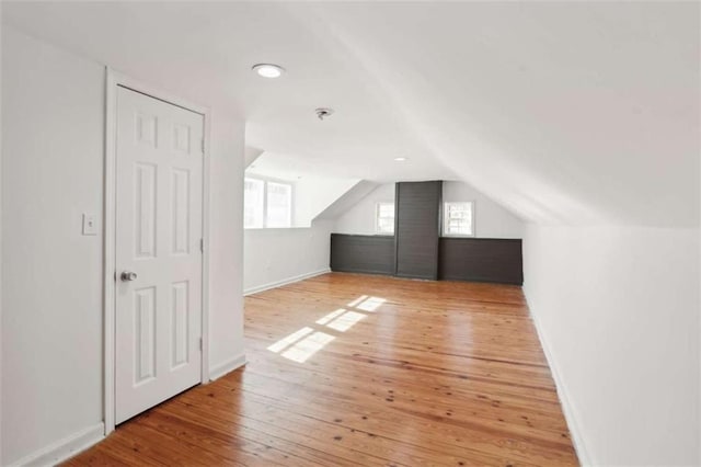 bonus room featuring vaulted ceiling and light hardwood / wood-style flooring