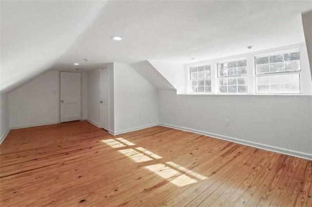 bonus room featuring light hardwood / wood-style floors and vaulted ceiling